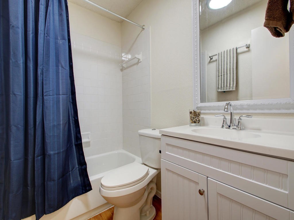 4906 Duval Street, Unit A Austin, TX 78751 - Photo 13 of 24 a bathroom with a sink a toilet a mirror and shower