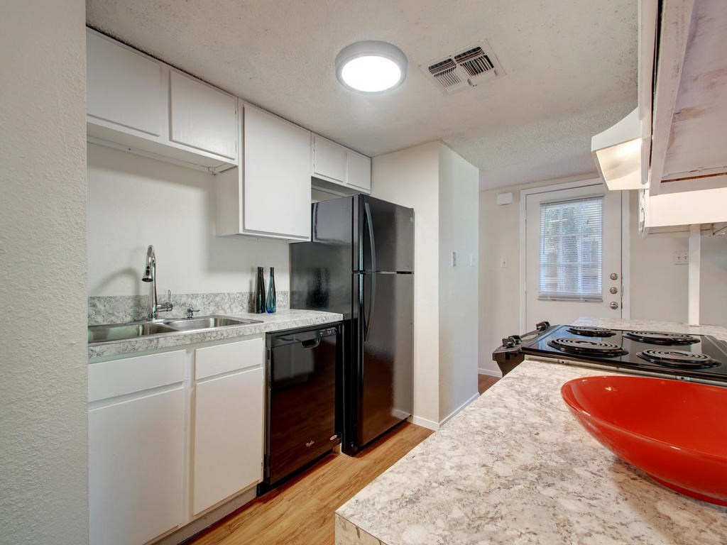 4906 Duval Street, Unit A Austin, TX 78751 - Photo 6 of 24 a kitchen with a sink stove and refrigerator