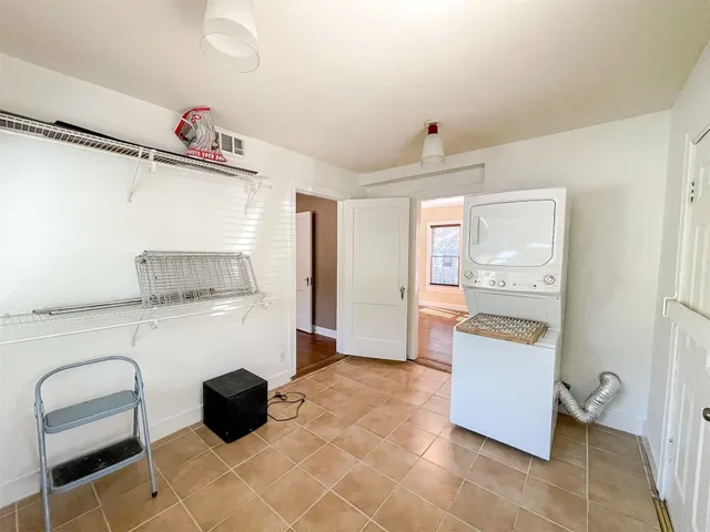 a kitchen with a refrigerator and white cabinets