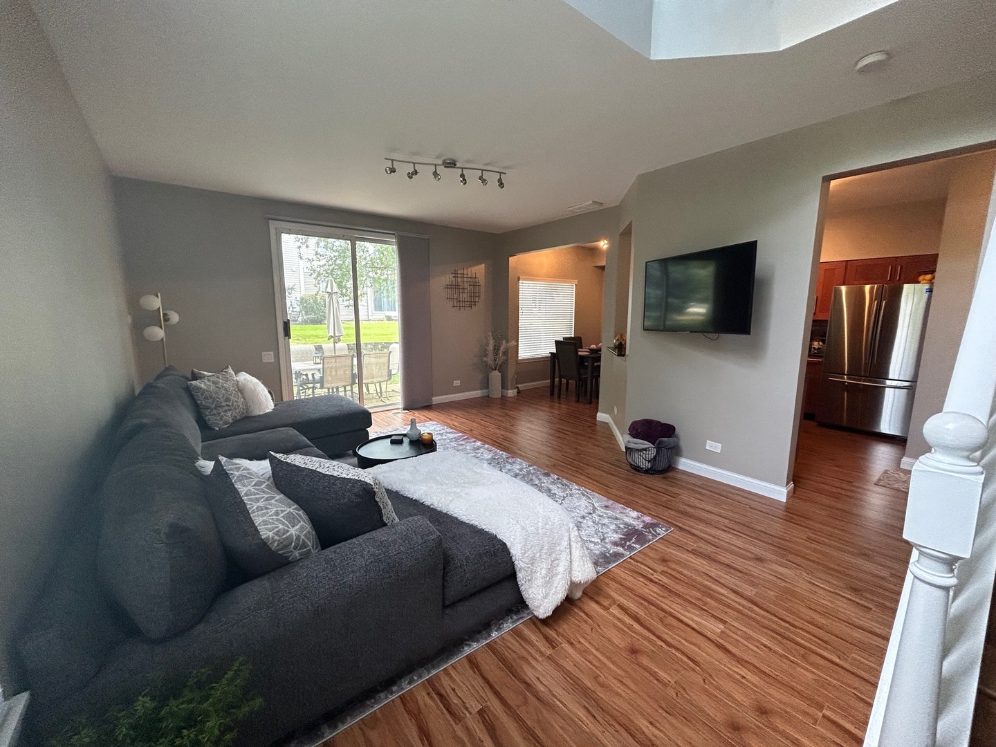 1561 Spaulding Road Bartlett, IL 60103 - Photo 7 of 25 a living room with furniture a flat screen tv and a large window