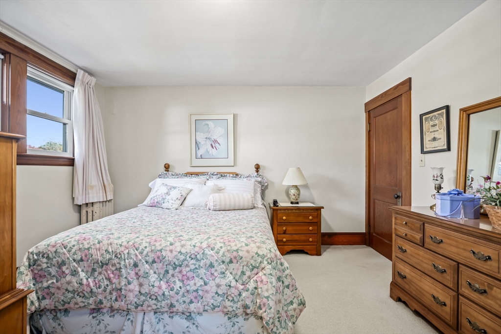 212 Elm Street Amesbury, MA 01913 - Photo 27 of 41 a bedroom with a bed and a dresser next to a window