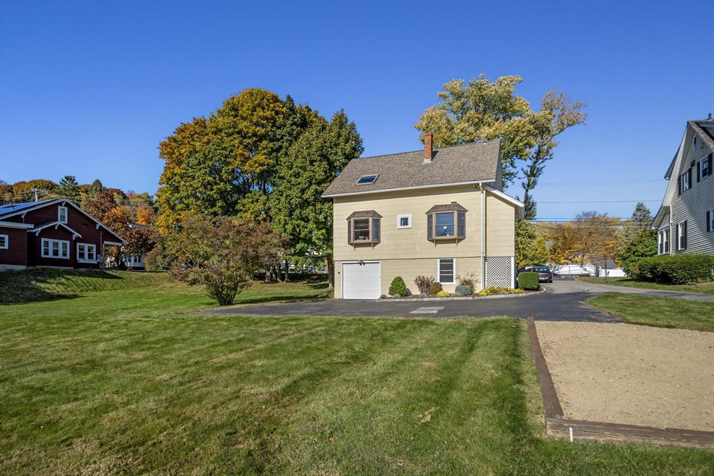 212 Elm Street Amesbury, MA 01913 - Photo 40 of 41 a front view of a house with a garden and trees