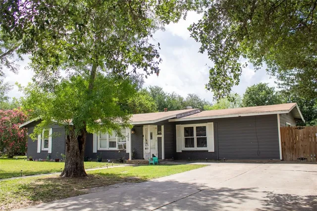 a front view of a house with a yard and trees