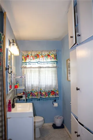a bathroom with a toilet sink and mirror