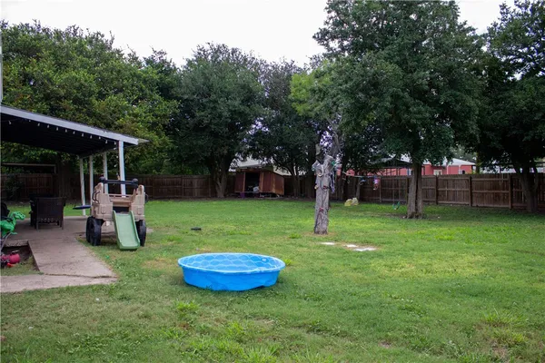 a view of a backyard with table and chairs and a slide