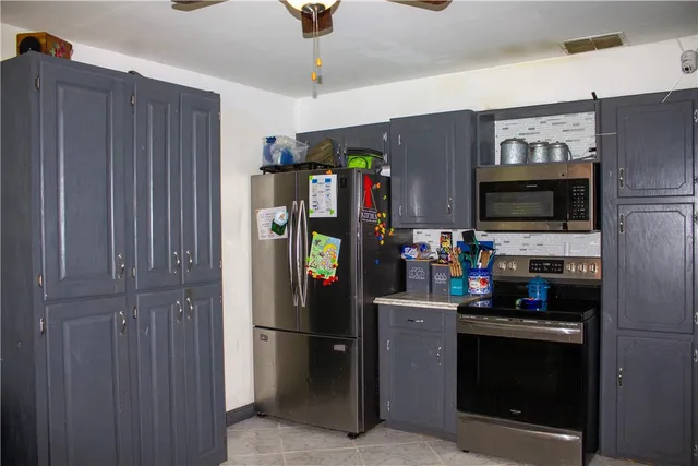 a kitchen with stainless steel appliances granite countertop a refrigerator and a stove top oven