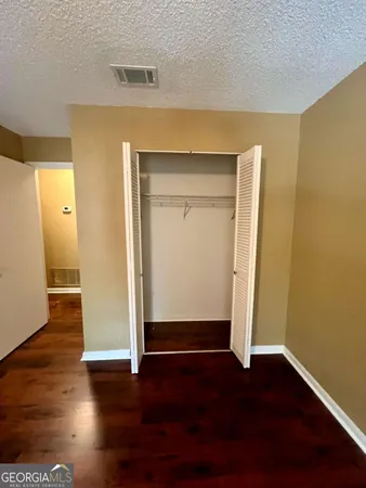 an empty room with wooden floor and closet