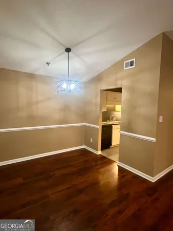 wooden floor in an empty room with a kitchen