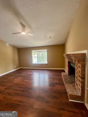 an empty room with wooden floor and fireplace
