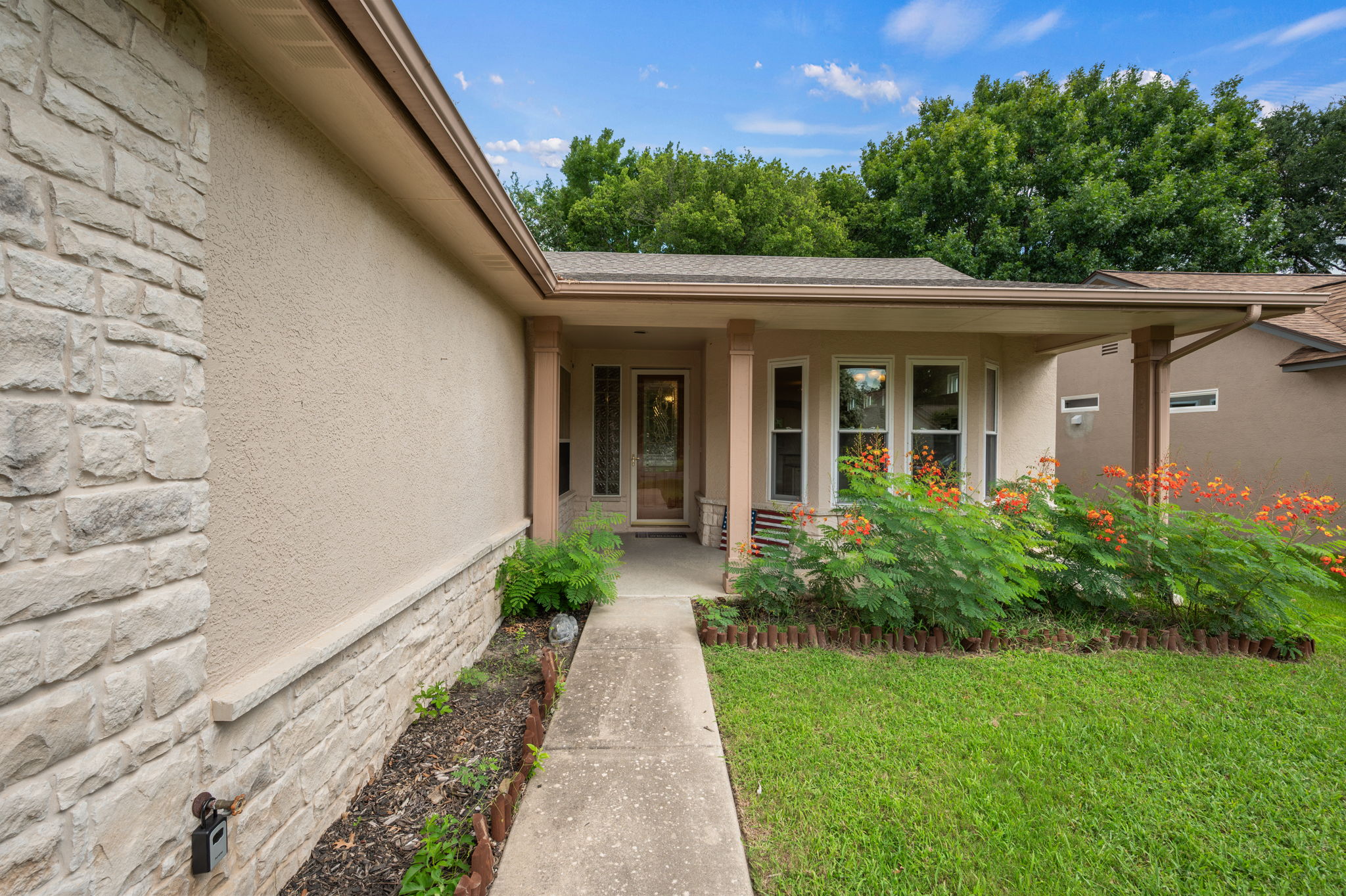 118 Bass Street Georgetown, TX 78633 - Photo 3 of 40 A well-maintained facade features stucco and stone accents, inviting all to discover its charming entrance.