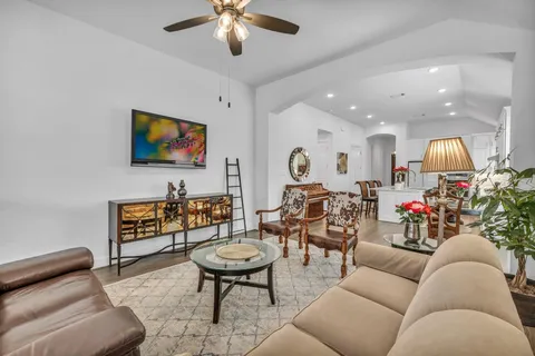 a living room with furniture kitchen view and a flat screen tv