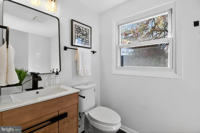 a bathroom with a toilet sink and mirror
