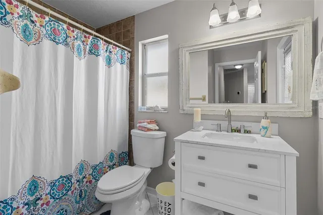 a bathroom with a toilet a sink and a mirror