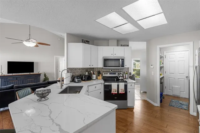 a kitchen with stainless steel appliances a stove a sink and a refrigerator