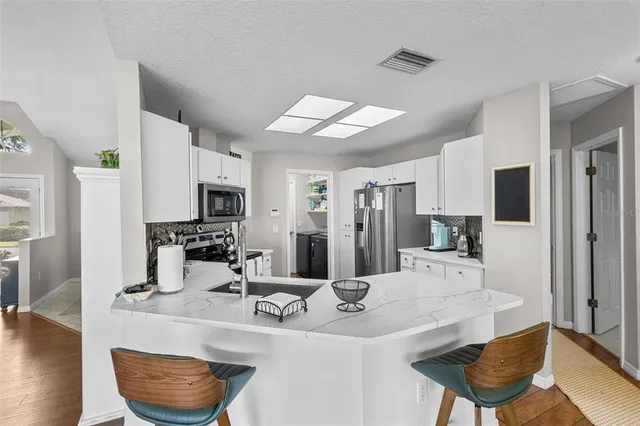 a kitchen with stainless steel appliances kitchen island granite countertop a sink and cabinets