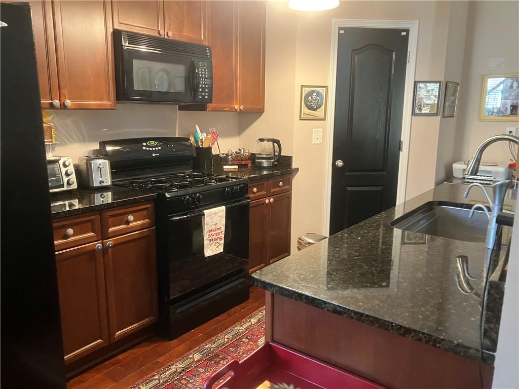 1665 Oakbrook Lake Drive Northwest Norcross, GA 30093 - Photo 16 of 24 a kitchen with stainless steel appliances granite countertop a sink a stove and a microwave