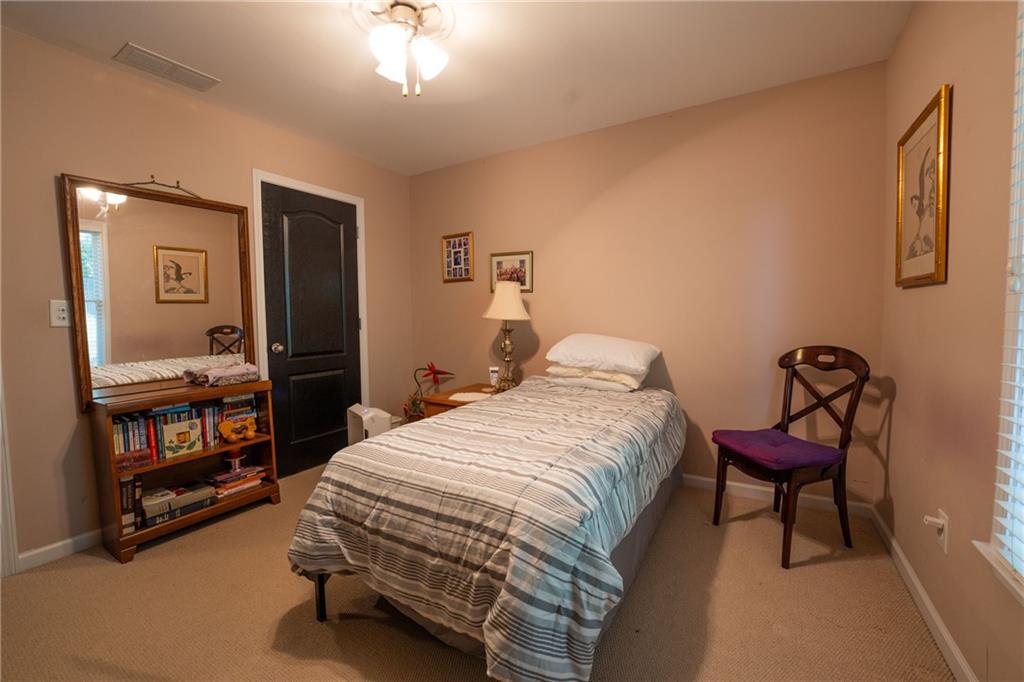 1665 Oakbrook Lake Drive Northwest Norcross, GA 30093 - Photo 22 of 24 a bedroom with a bed and a chandelier