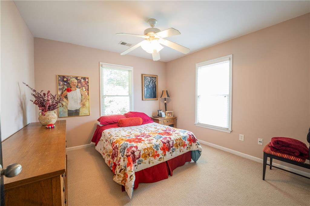 1665 Oakbrook Lake Drive Northwest Norcross, GA 30093 - Photo 23 of 24 a bedroom with a bed and a chandelier