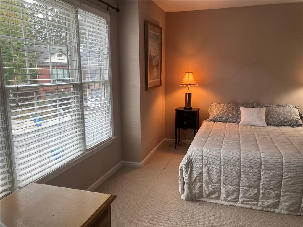 1665 Oakbrook Lake Drive Northwest Norcross, GA 30093 - Photo 8 of 24 a bedroom with a bed and a window