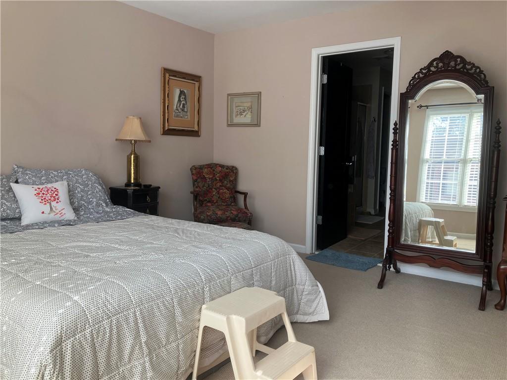 1665 Oakbrook Lake Drive Northwest Norcross, GA 30093 - Photo 10 of 24 a bedroom with a bed and glass door