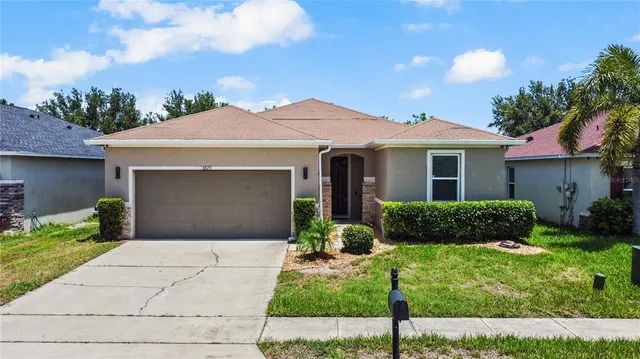 a front view of a house with a yard and potted plants