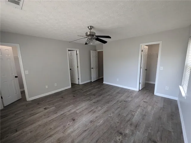 a view of a livingroom with wooden floor and a ceiling fan