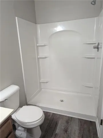 a white toilet sitting next to a shower