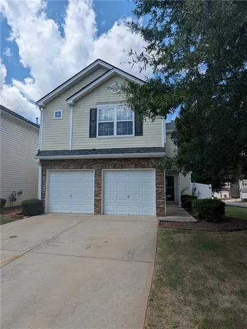 a front view of a house with a yard and garage