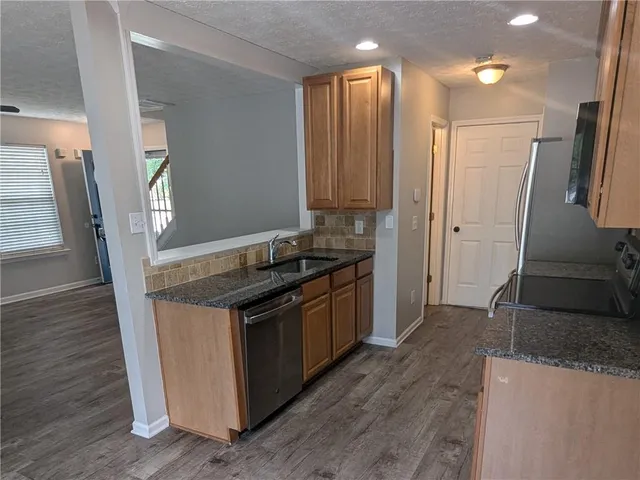a kitchen with stainless steel appliances granite countertop a stove and a refrigerator