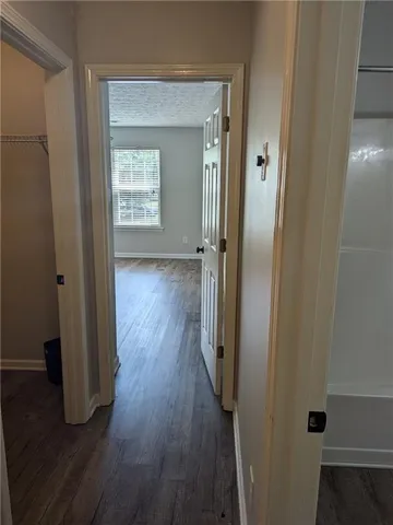 a view of a hallway with wooden floor and closet area