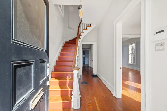 a view of entryway and hall with wooden floor