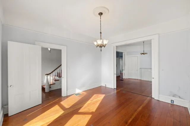 a view of a room with wooden floor staircase and a kitchen