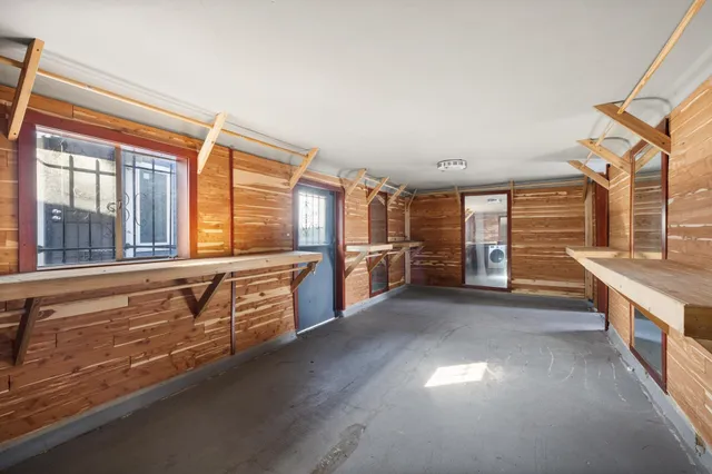 a view of a house with a bed and wooden walls