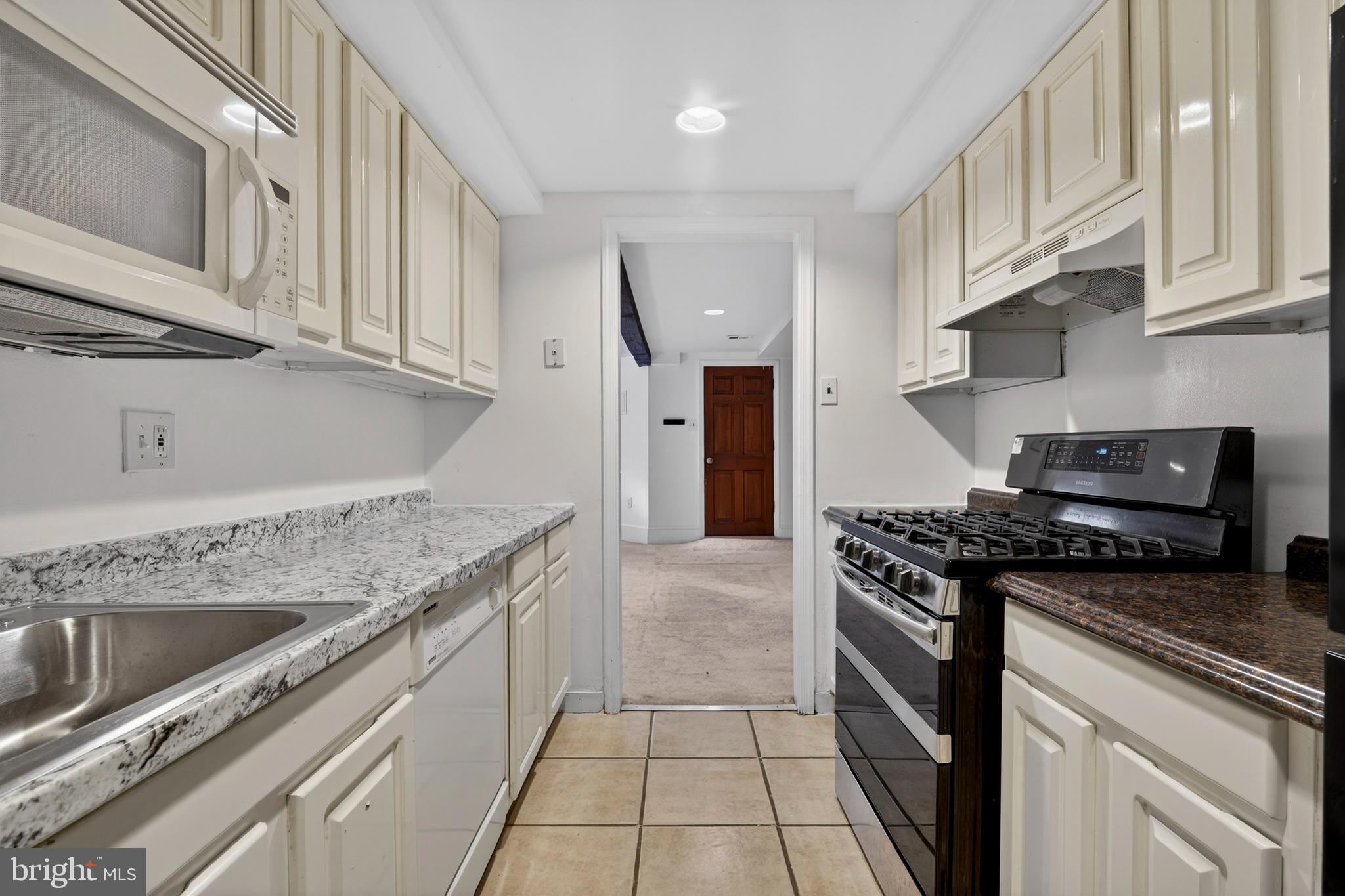1351 Monroe Street Northwest Washington, DC 20010 - Photo 8 of 23 a kitchen with granite countertop a stove sink and cabinets