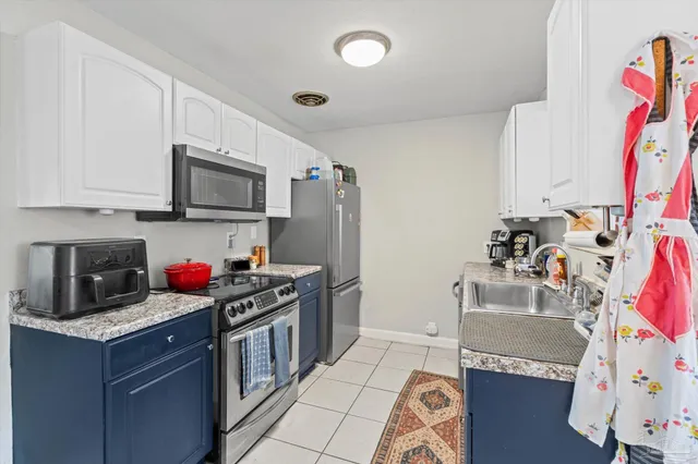 a kitchen with stainless steel appliances granite countertop a stove top oven a sink dishwasher and a microwave with wooden floor