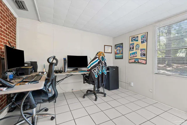 a view of a workspace with furniture and a window