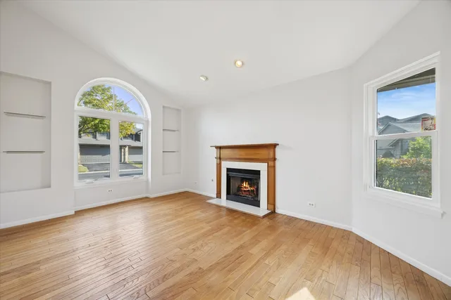 a view of an empty room with a window and a fireplace