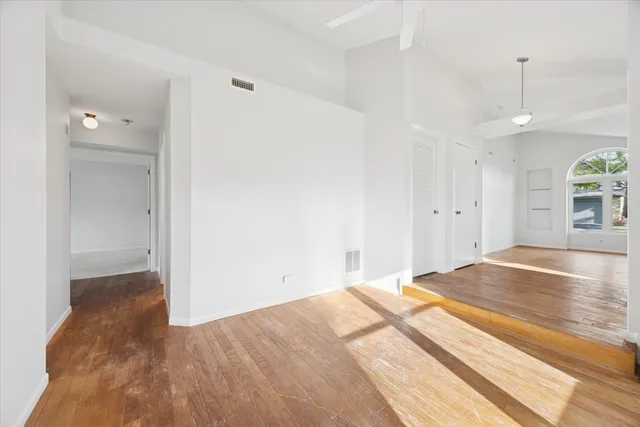 a view of empty room with wooden floor and window