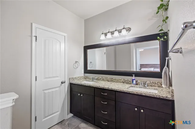 a bathroom with a granite countertop sink and a mirror