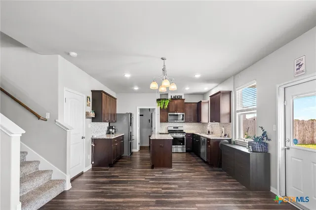 a large kitchen with a center island and stainless steel appliances