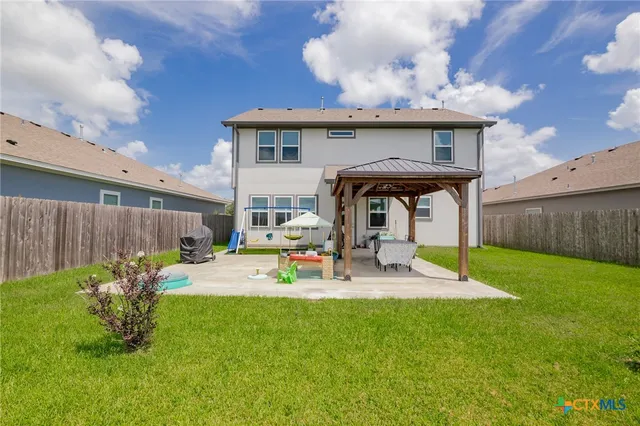 a view of a backyard with table and chairs with wooden fence