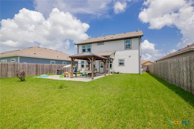 a view of a house with backyard and sitting area