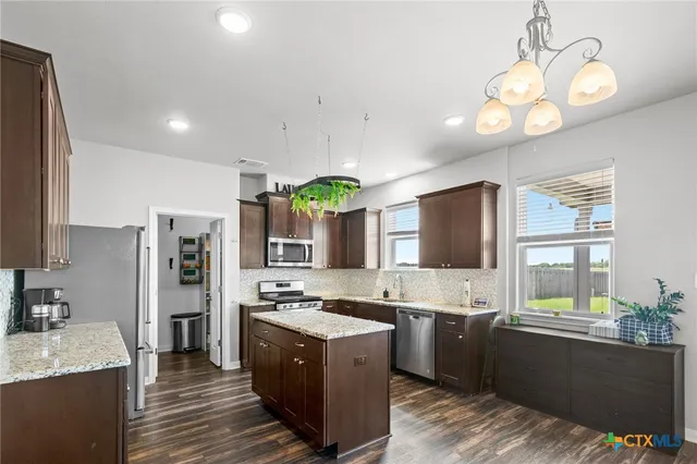 a large kitchen with a large counter top cabinets and stainless steel appliances