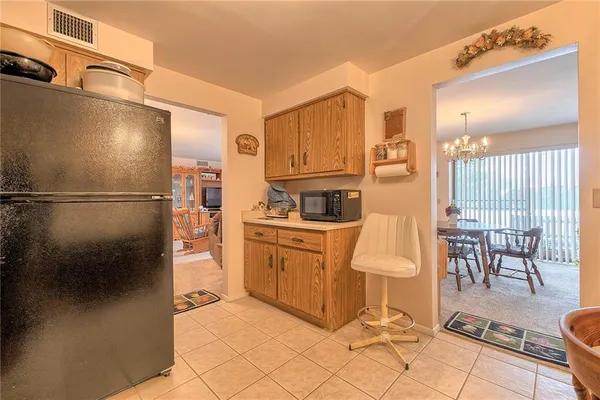 a kitchen with granite countertop a refrigerator a stove top oven and cabinets