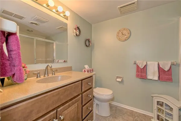 a bathroom with a sink mirror vanity and toilet