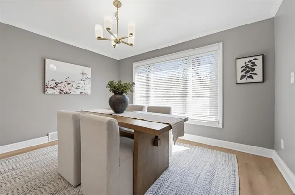 a dining room with a window wooden floor and a chandelier