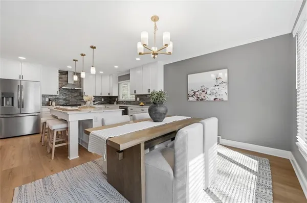 a kitchen with stainless steel appliances a dining table chairs stove and refrigerator