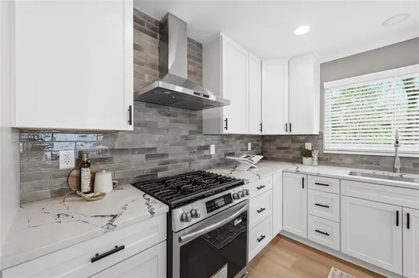 a kitchen with white cabinets and appliances