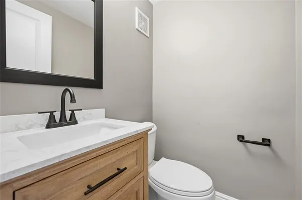 a bathroom with a sink a toilet and mirror