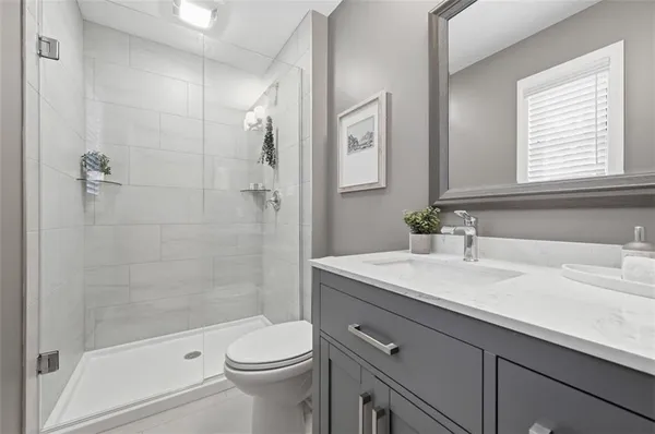 a bathroom with a sink a toilet and shower